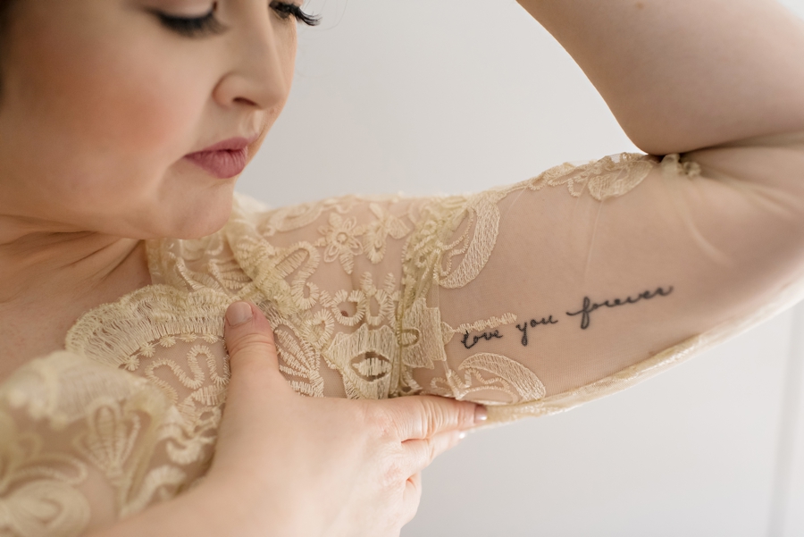 A beautiful tattoo shines through the brides wedding dress.